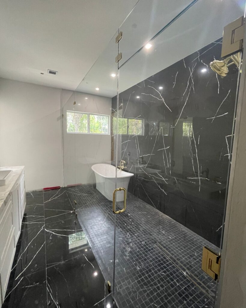 Frameless tempered glass shower enclosure installed in modern bathroom